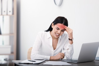 Image of Woman suffering from migraine at workplace in office 