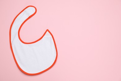 Photo of New baby bib on pink background, top view. Space for text