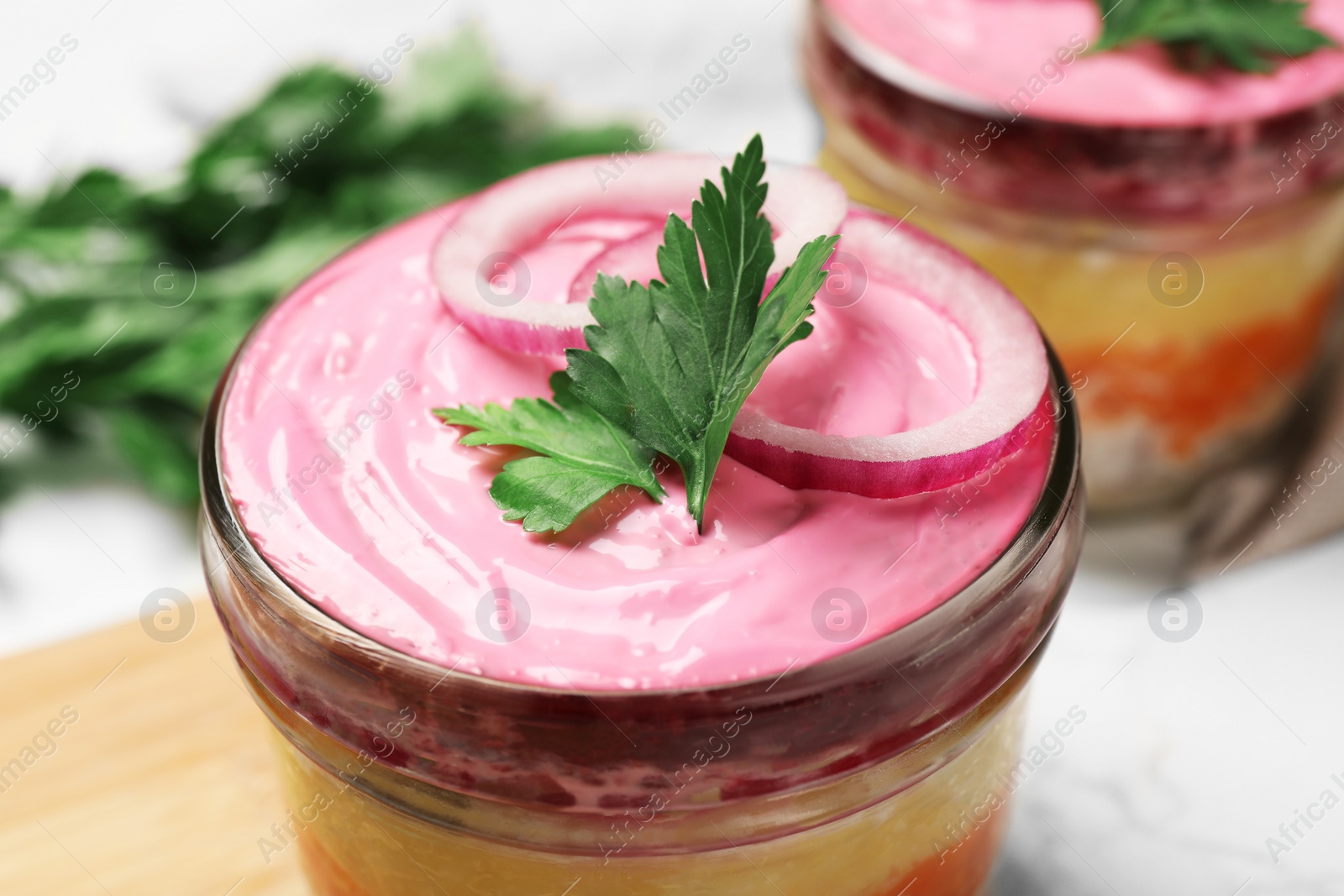 Photo of Herring under fur coat salad in glass bowl, closeup. Traditional Russian dish