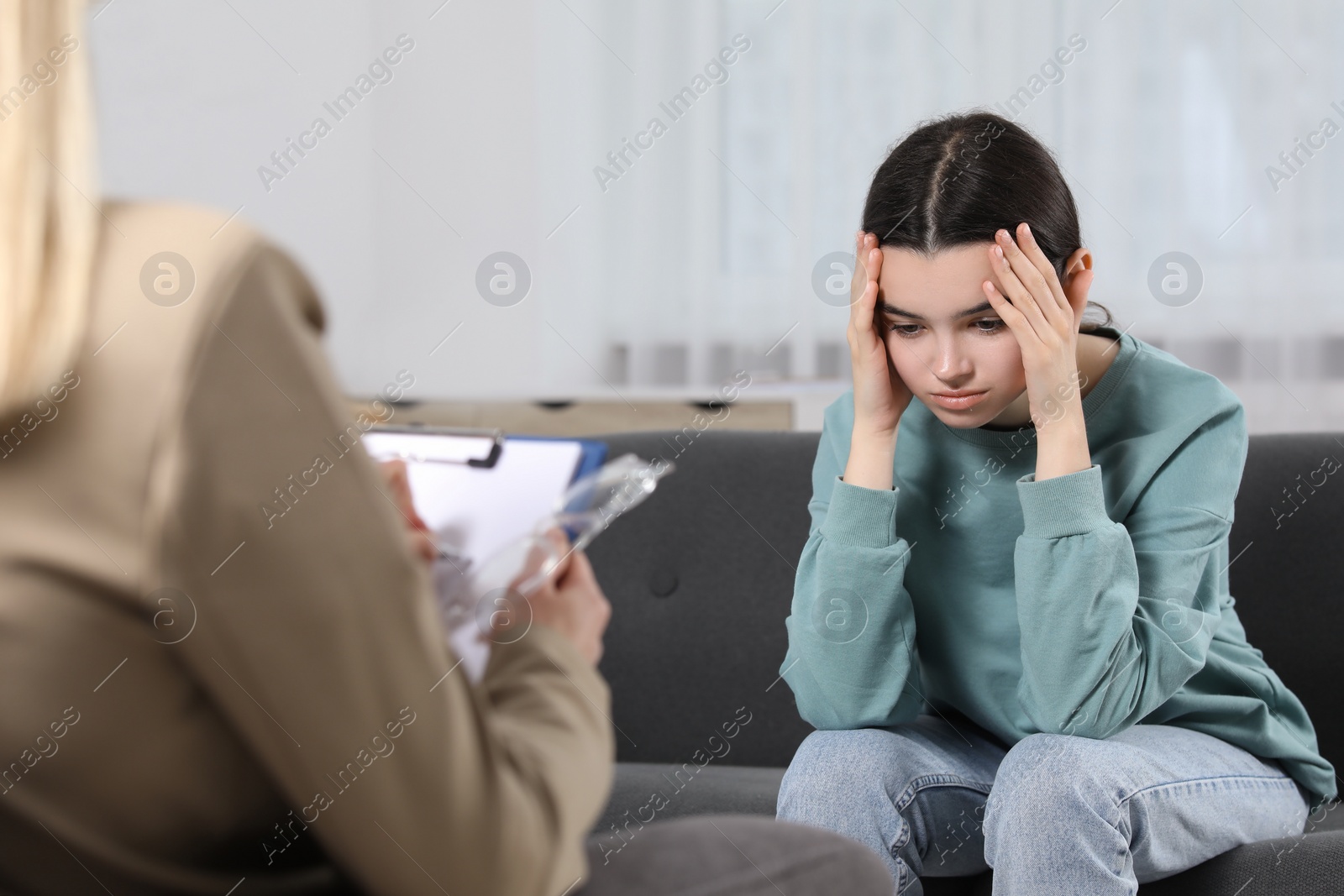 Photo of Psychologist working with teenage girl in office. Teenager problems