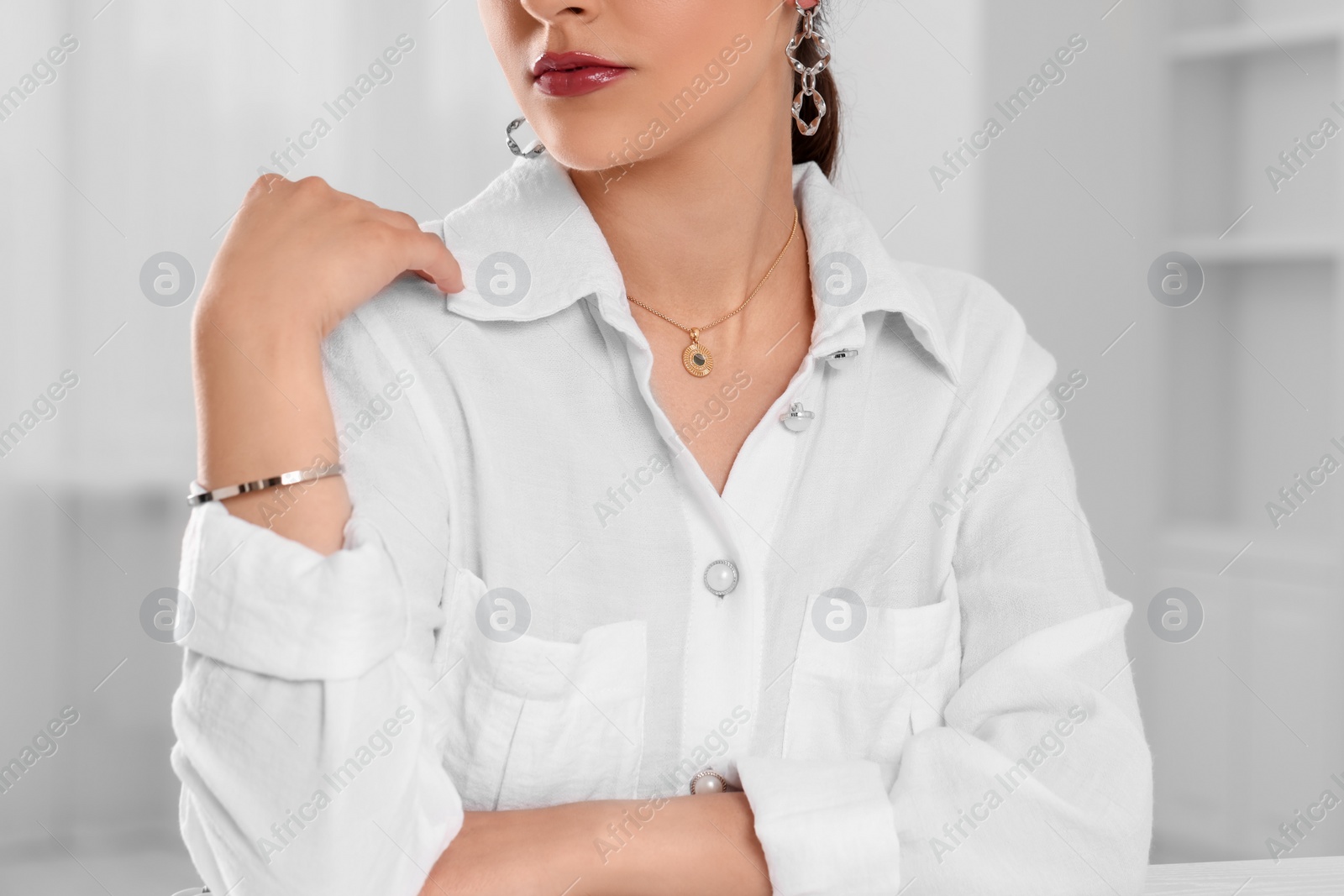 Photo of Beautiful woman with elegant jewelry indoors, closeup