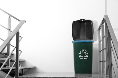 Photo of Trash bin on stair landing indoors. Waste recycling