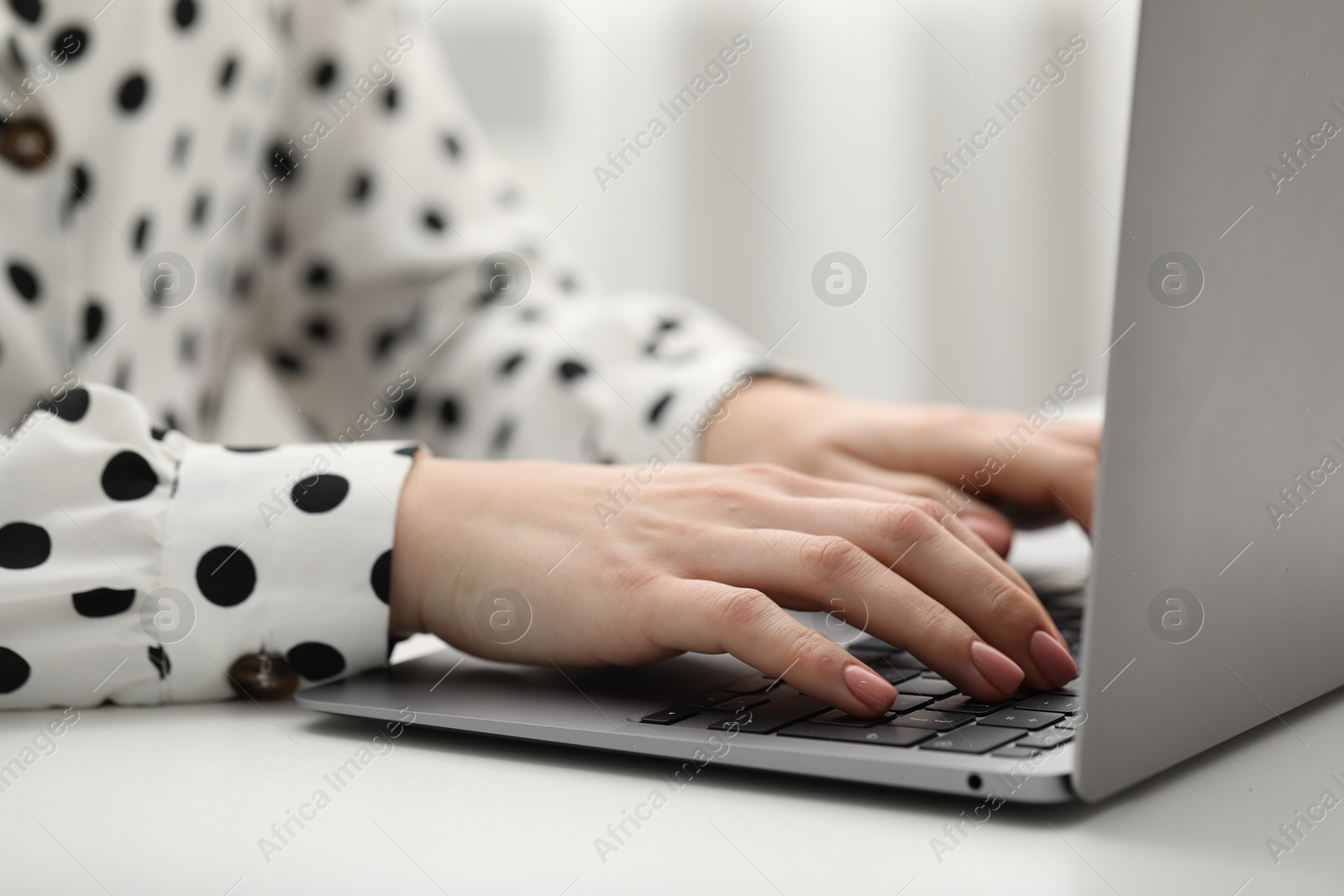 Photo of E-learning. Woman using laptop during online lesson at table indoors, closeup