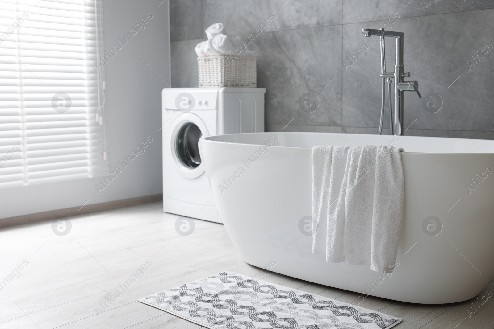 Photo of Fresh white towels on tub in bathroom. Space for text