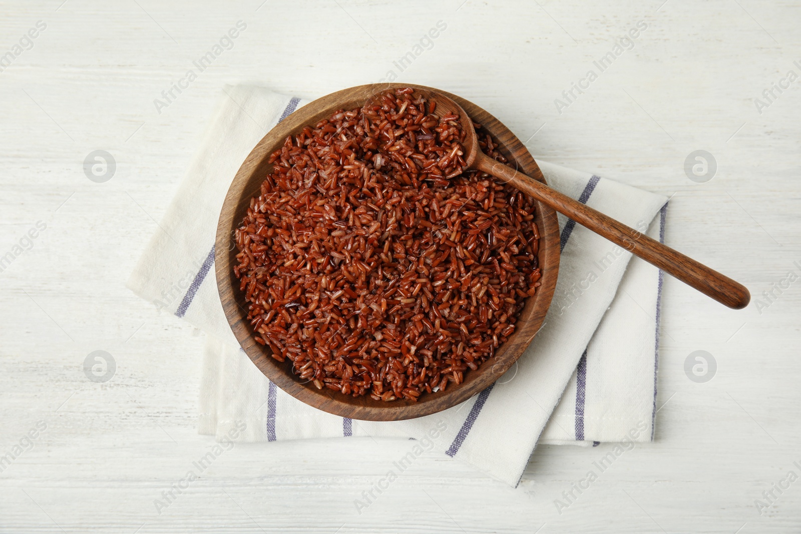 Photo of Flat lay composition with delicious cooked brown rice on white wooden table