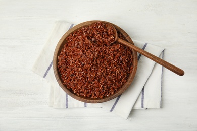 Flat lay composition with delicious cooked brown rice on white wooden table