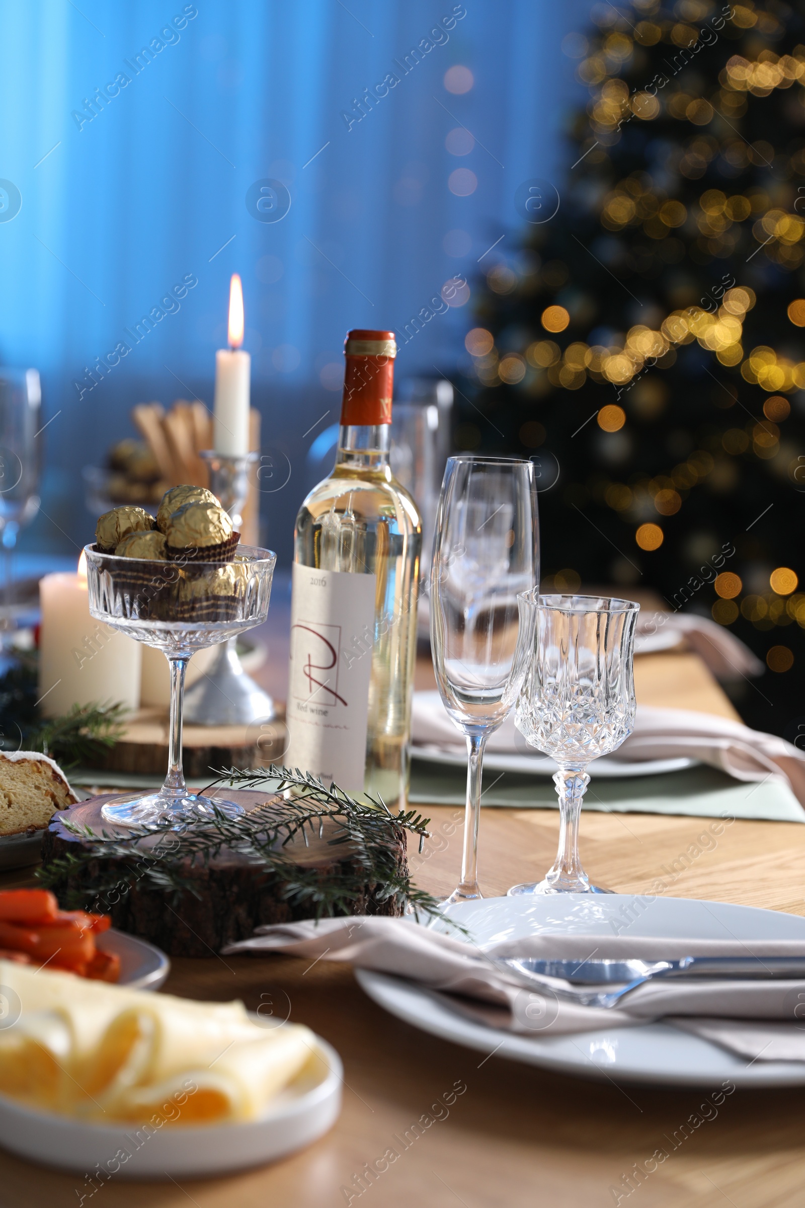 Photo of Christmas table setting with festive decor and dishware indoors