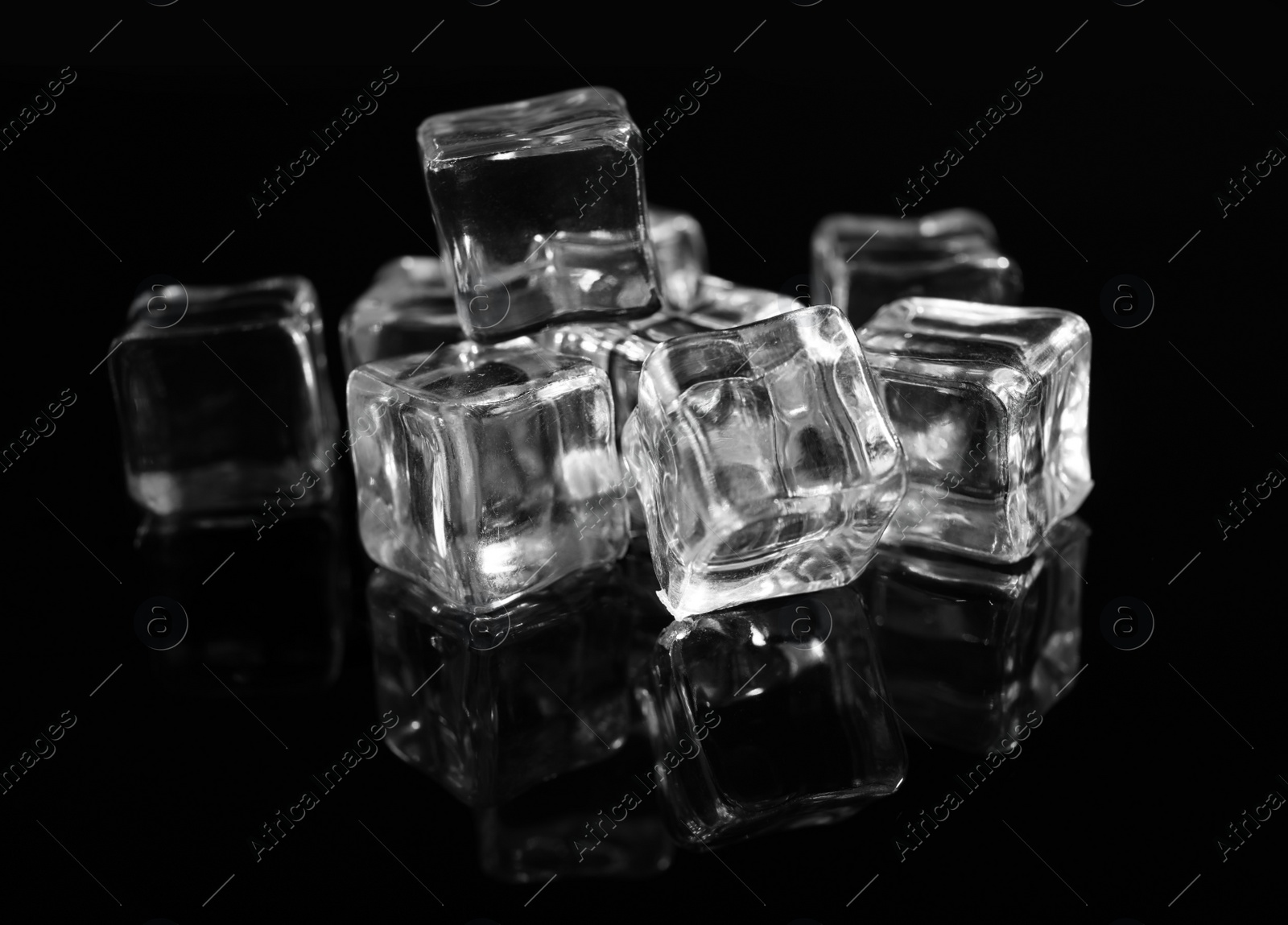 Photo of Pile of crystal clear ice cubes on black background