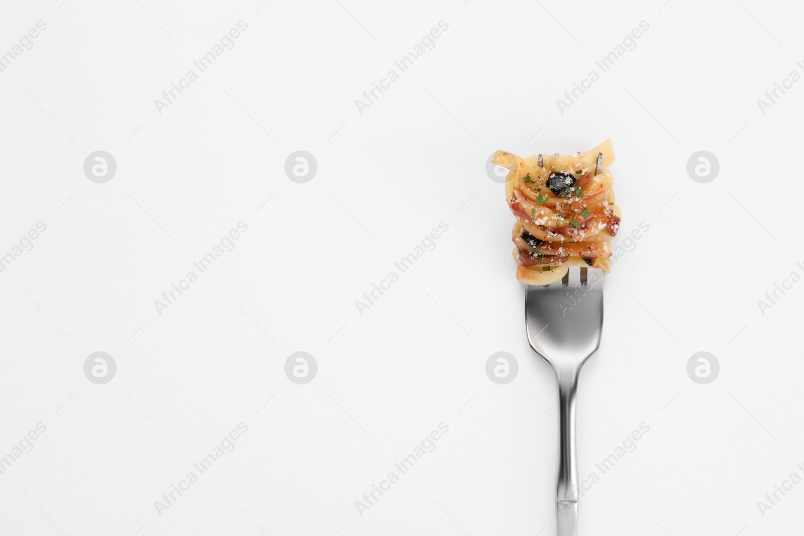 Photo of Fork with tasty pasta on white background, top view. Space for text