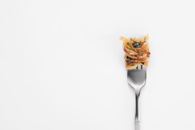 Fork with tasty pasta on white background, top view. Space for text