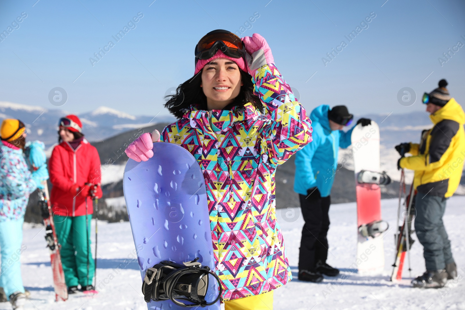 Photo of Young woman with snowboard at ski resort. Winter vacation