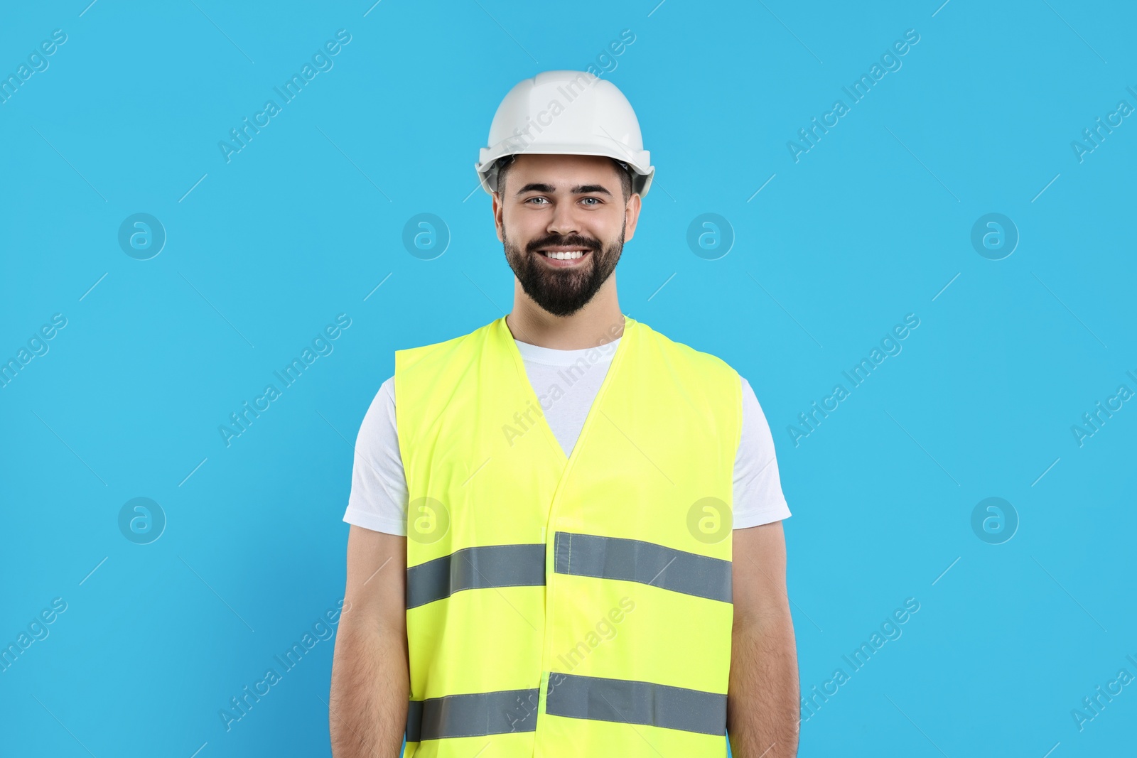 Photo of Engineer in hard hat on light blue background