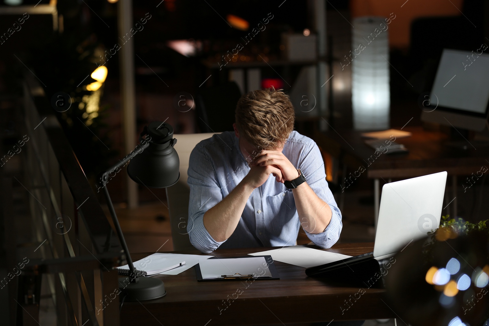 Photo of Young man working in office at night