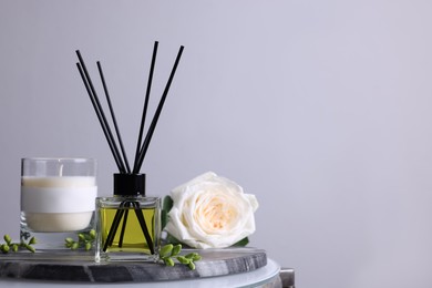 Photo of Composition with aromatic reed air freshener on glass table, space for text