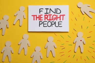 Photo of Find the right people. Human paper figure with drawn heart among others without it on yellow background, flat lay