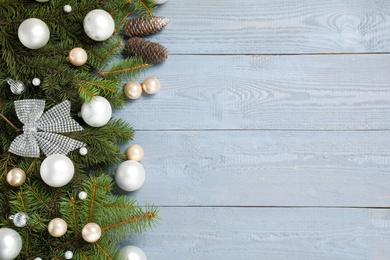 Fir branches with Christmas decoration on grey wooden background, flat lay. Space for text