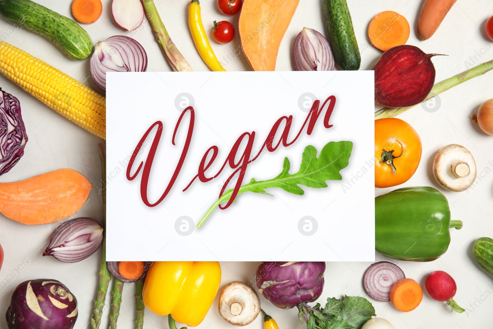 Image of Paper card with word Vegan and fresh vegetables on white background, flat lay