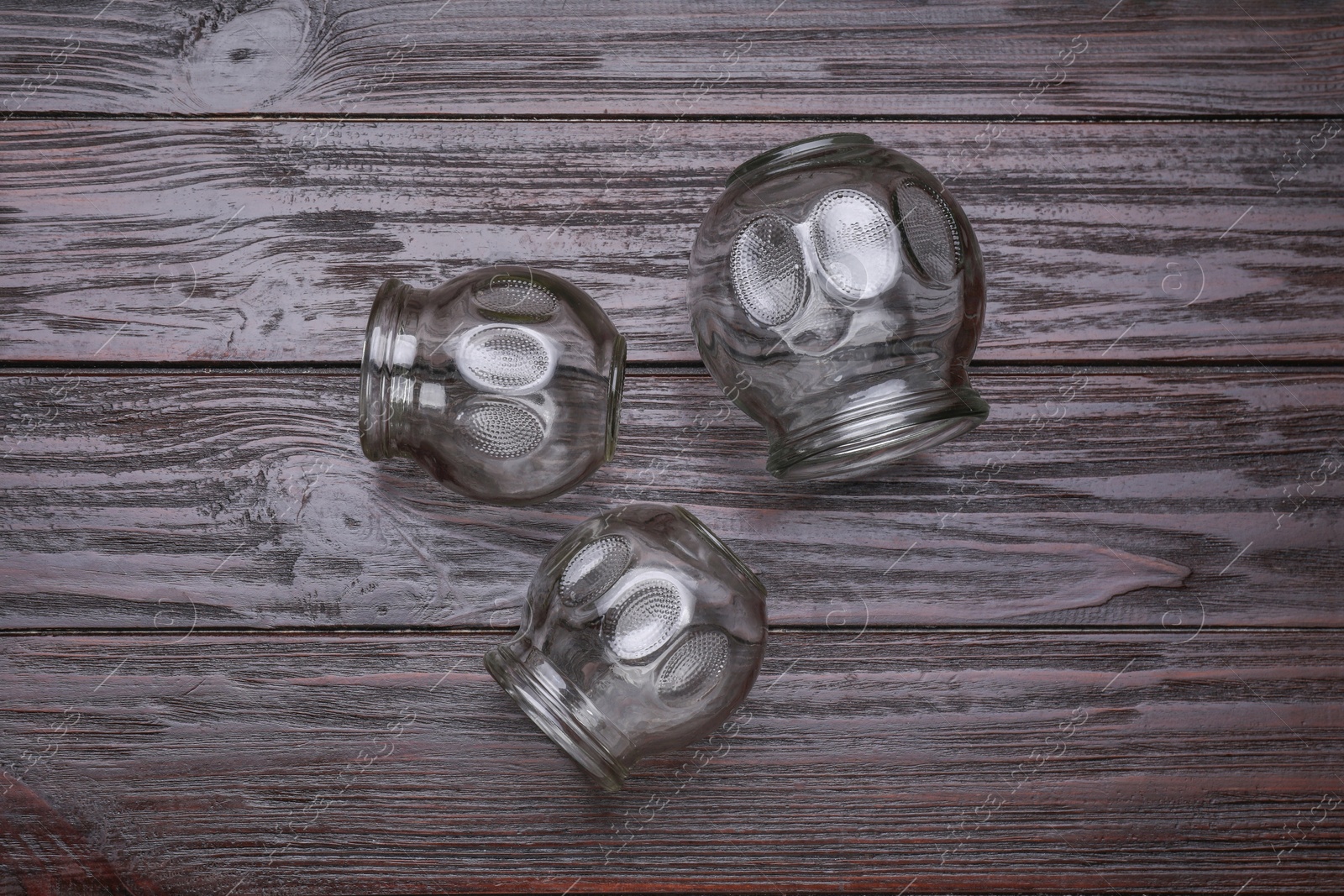 Photo of Glass cups on wooden table, flat lay. Cupping therapy