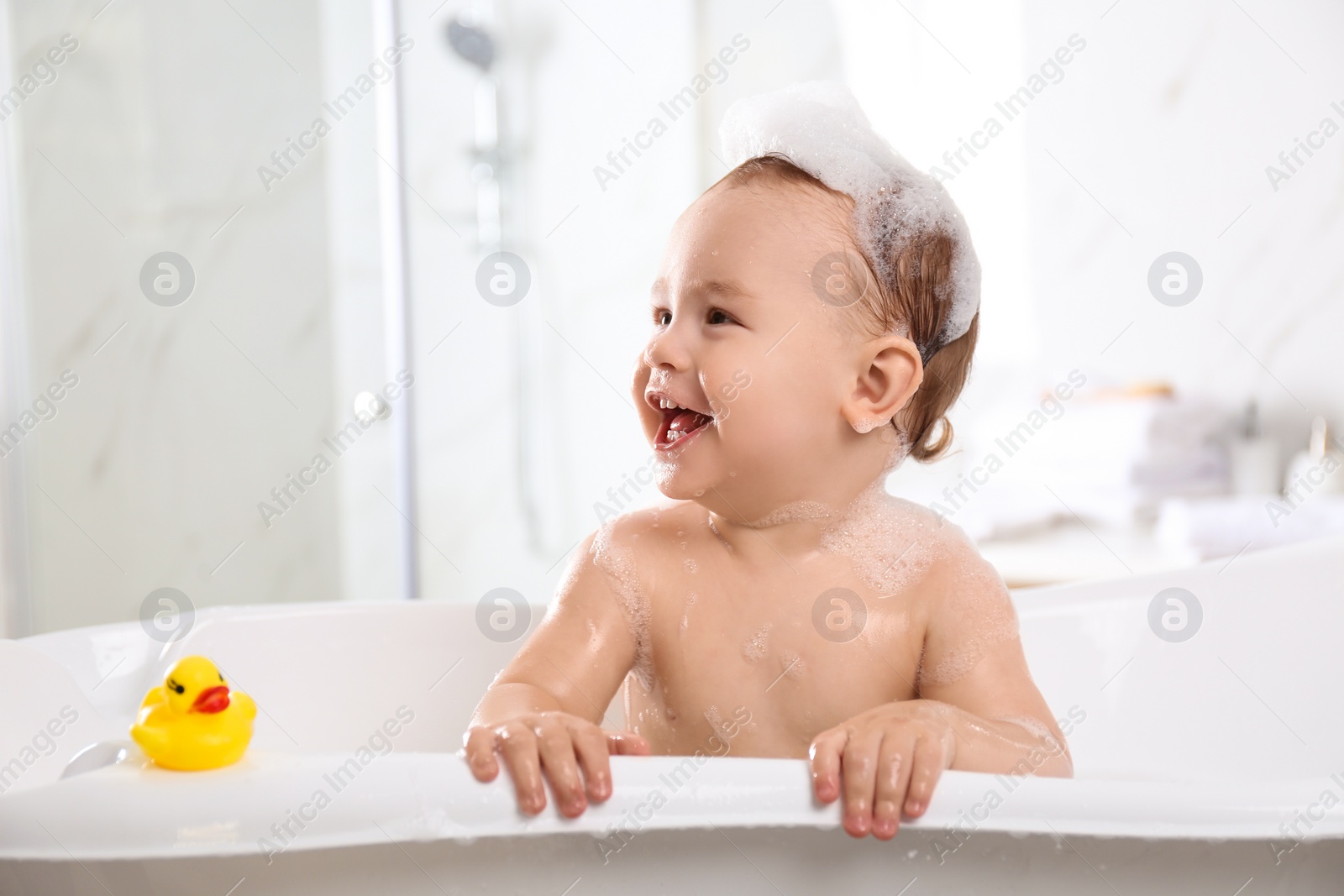 Photo of Cute little baby in bathtub at home