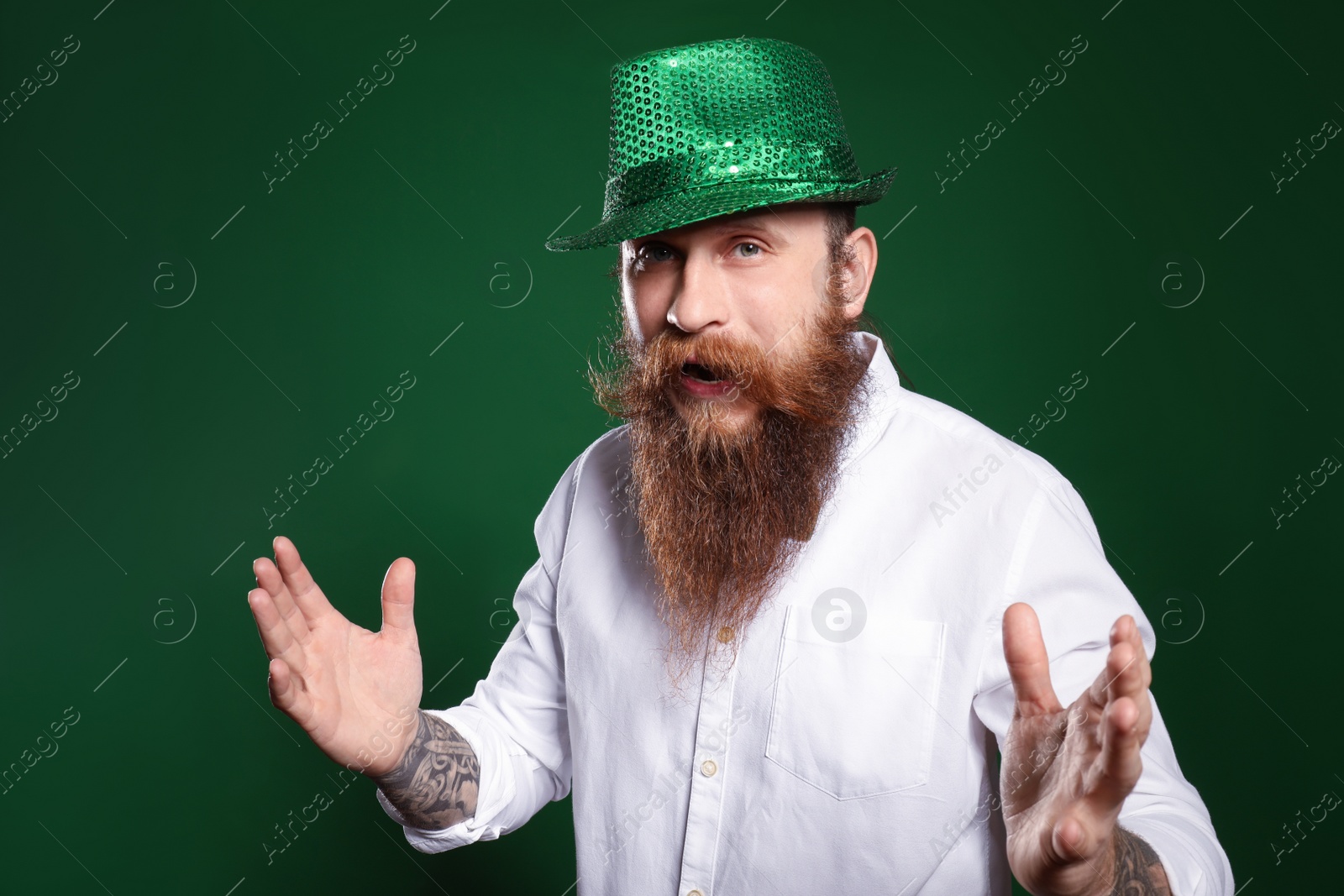 Photo of Bearded man in green hat on color background. St. Patrick's Day celebration