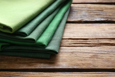 Photo of Different kitchen napkins on wooden table, closeup. Space for text