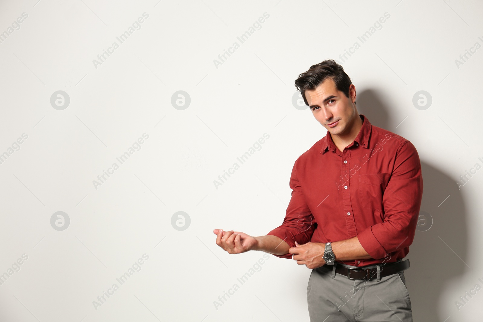 Photo of Handsome young man in stylish clothes on light beige background. Space for text