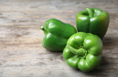 Photo of Raw ripe paprika peppers on wooden background