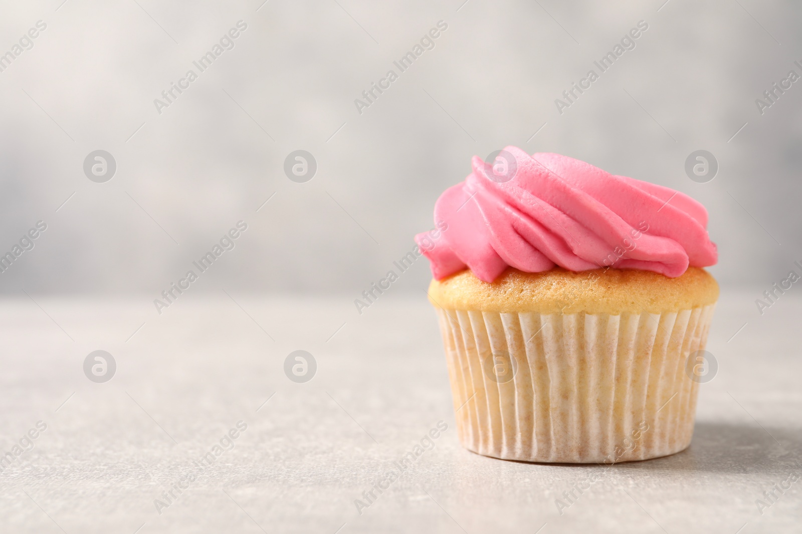 Photo of Delicious cupcake with bright cream on gray background, space for text