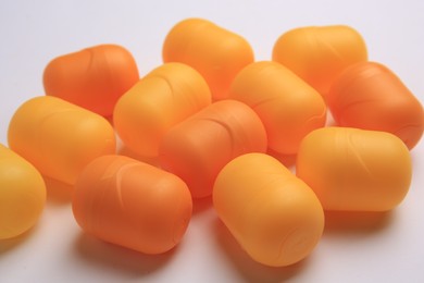 Sveti Vlas, Bulgaria - June 30, 2023: Orange plastic capsules from Kinder Surprise Eggs on white background, closeup