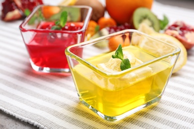 Glass bowls of tasty jelly desserts on table