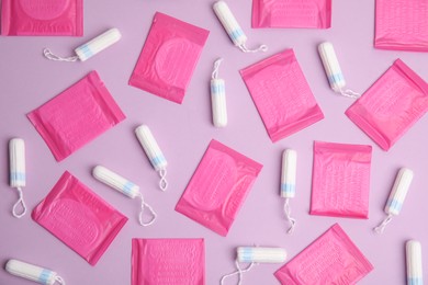 Photo of Tampons and pantyliners on lilac background, flat lay