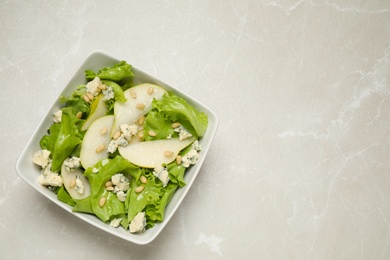 Photo of Fresh salad with pear on light table, top view. Space for text