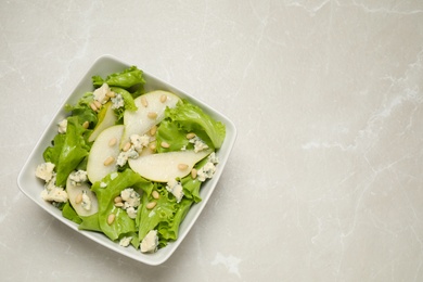 Fresh salad with pear on light table, top view. Space for text