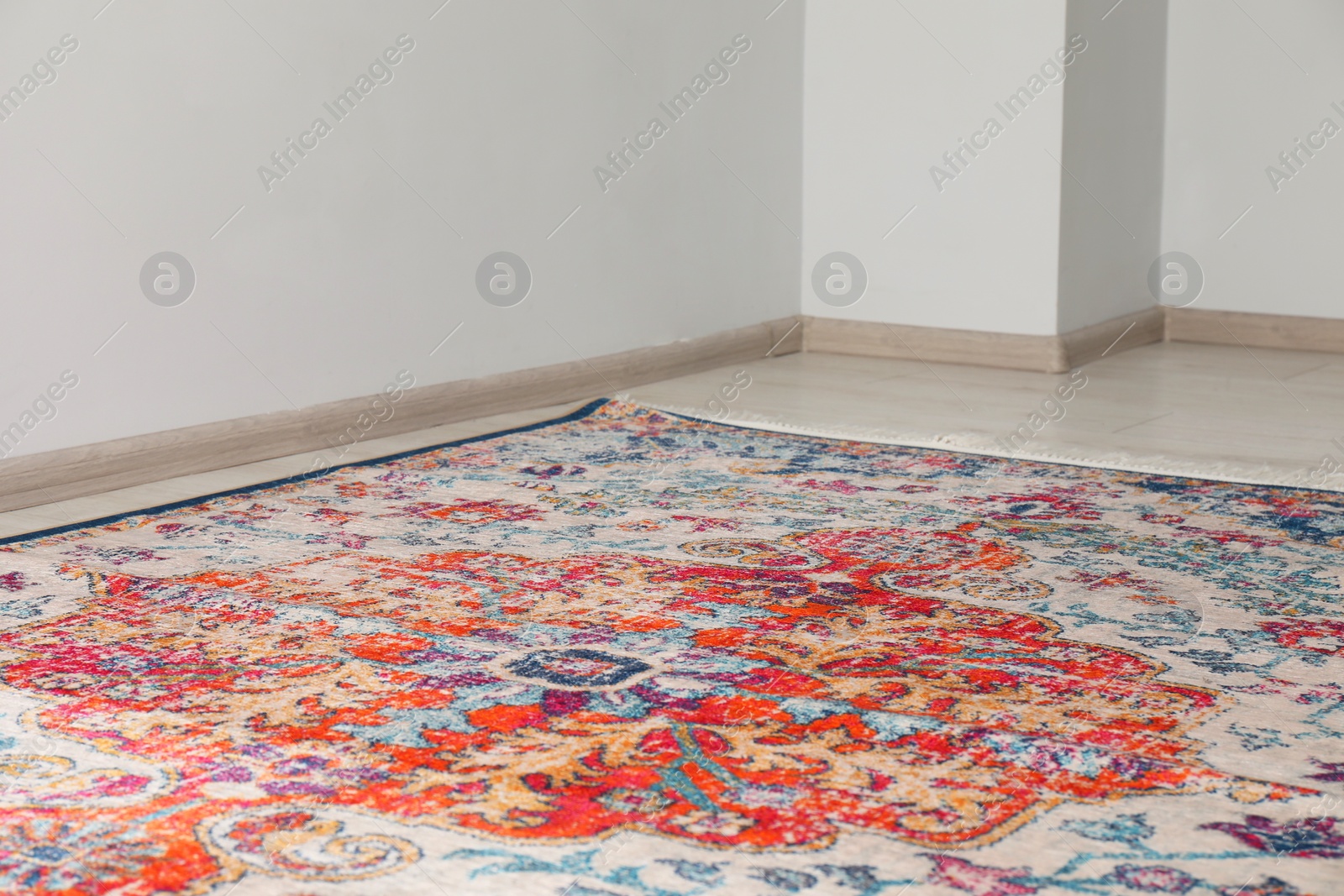 Photo of Soft carpet with pattern on white laminated floor indoors