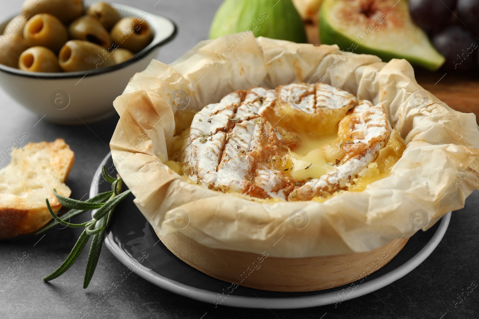 Photo of Tasty baked brie cheese on grey table, closeup