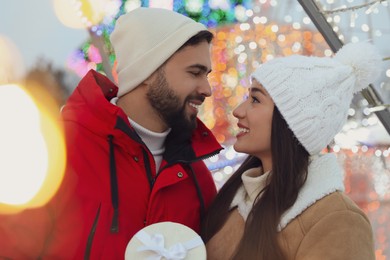 Photo of Happy young couple spending time together at winter fair. Christmas celebration