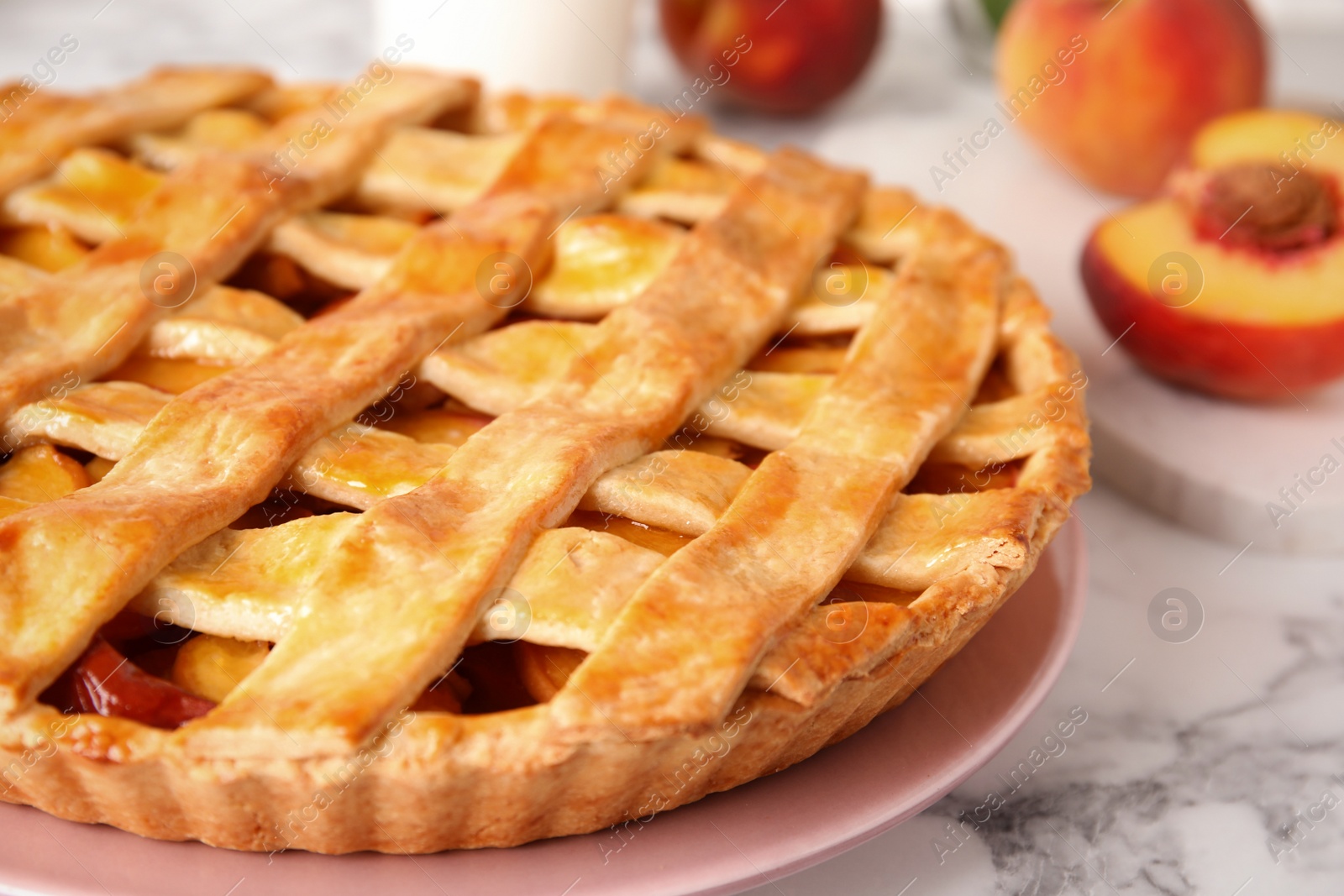 Photo of Delicious peach pie on white marble table, closeup