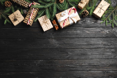 Flat lay composition with Christmas gift boxes and fir branches on wooden background