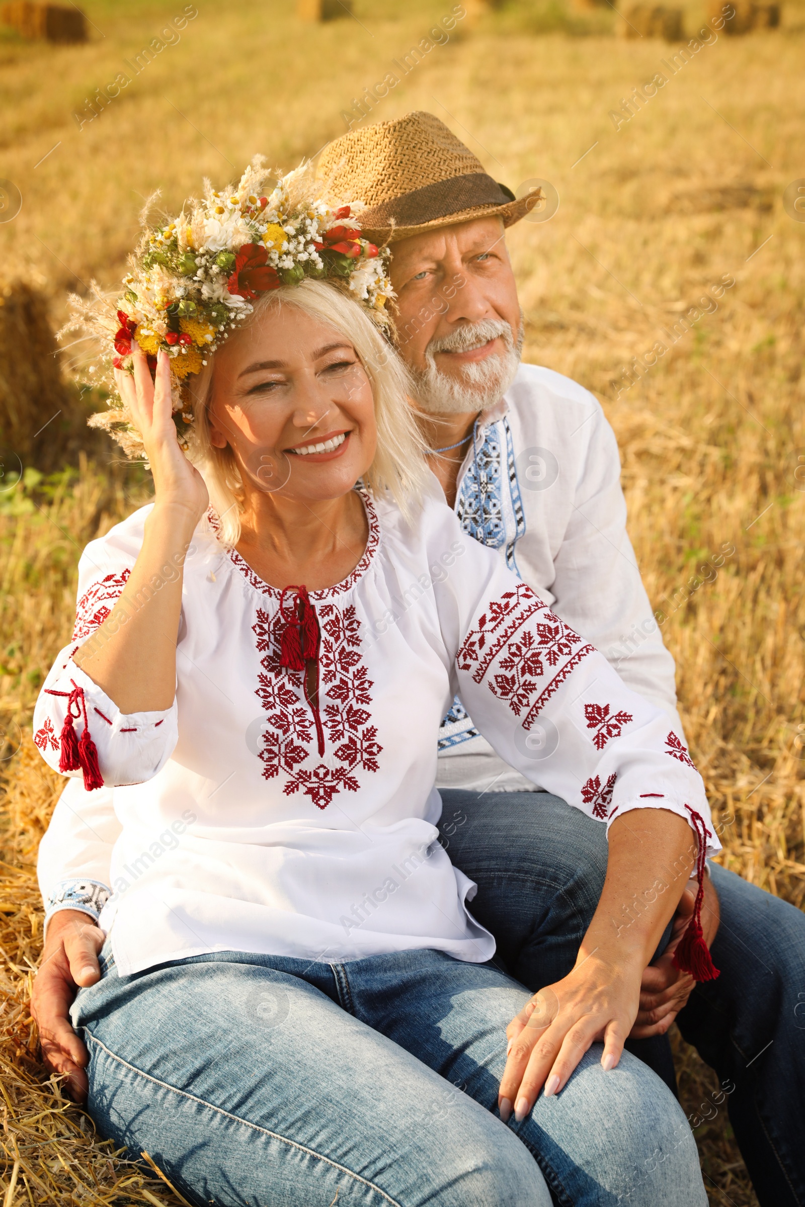 Photo of Happy mature couple wearing Ukrainian national clothes in field