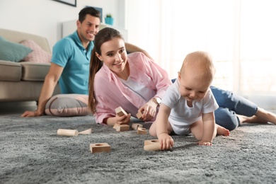 Adorable little baby crawling near parents at home