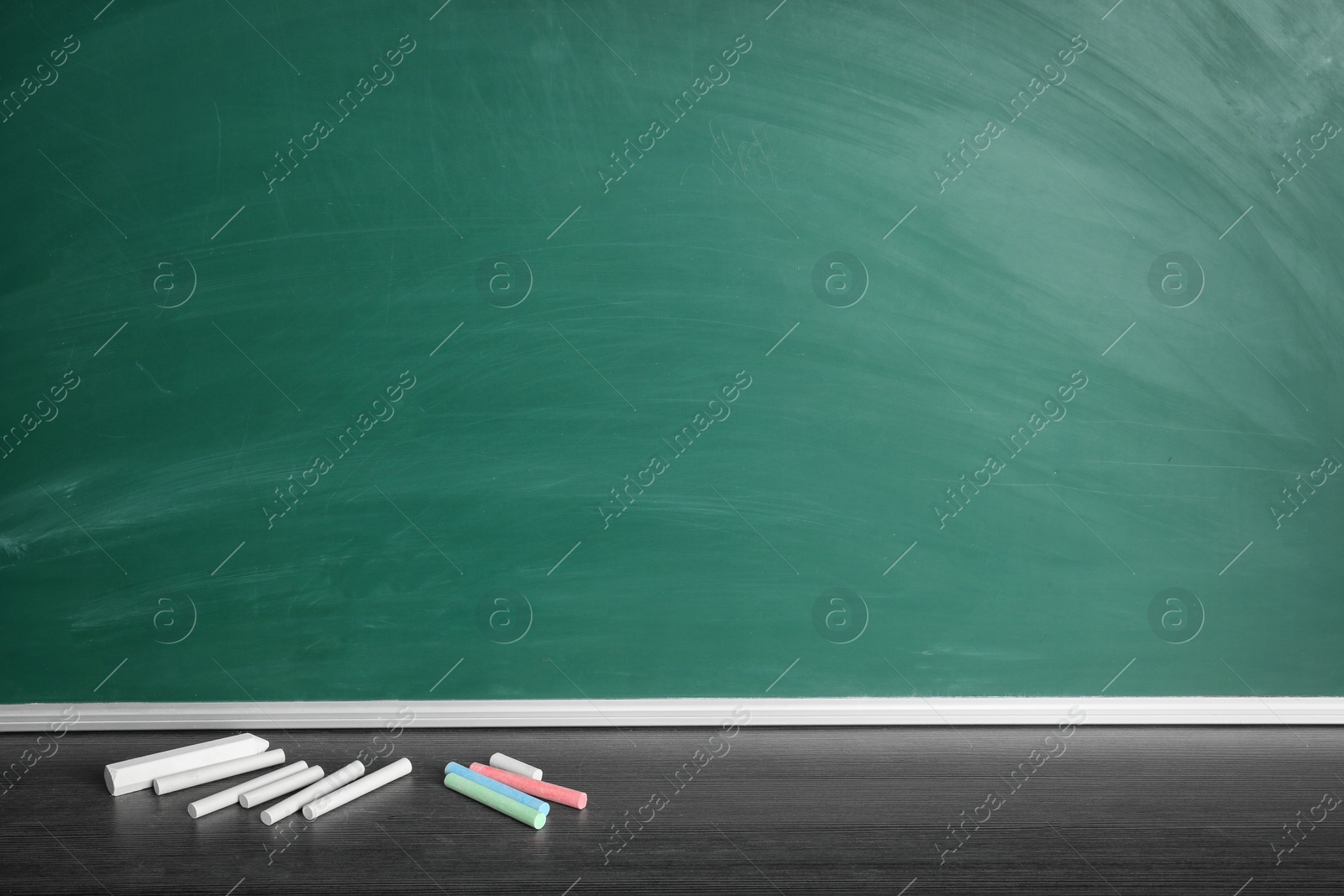 Photo of Chalk sticks on table near board in classroom