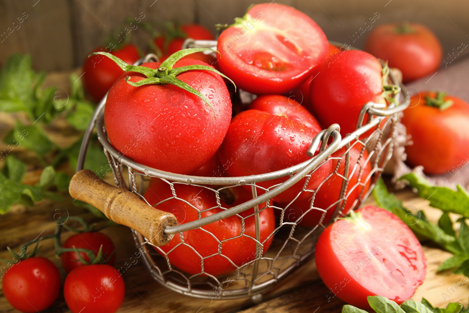 Photo of Fresh ripe tomatoes with leaves on wooden table, closeup