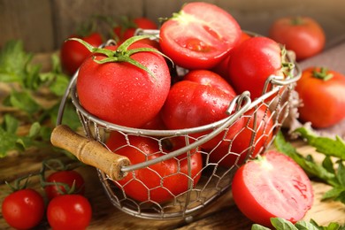 Photo of Fresh ripe tomatoes with leaves on wooden table, closeup