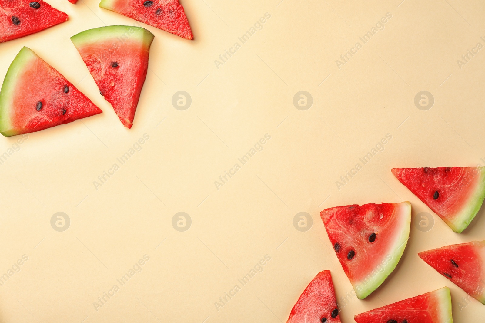 Photo of Slices of ripe watermelon on color background, top view with space for text