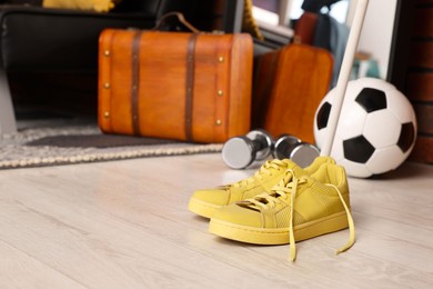 Photo of Suitcase, ball, dumbbells and sneakers in stylish teenager's room. Space for text