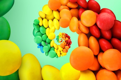 Image of Whirl of colorful candies on mint color background