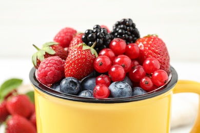 Photo of Mix of ripe berries in mug, closeup