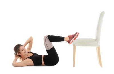 Photo of Young woman exercising with chair on white background. Home fitness