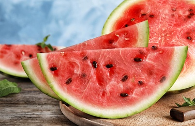 Wooden board with juicy watermelon slices on table