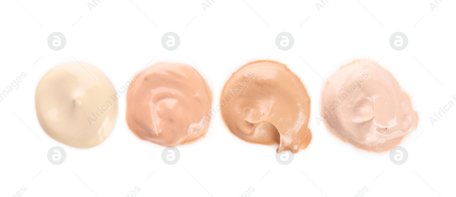 Photo of Different shades of liquid foundation on white background. Professional makeup products